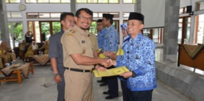 Wakil Bupati Garut Helmi Budiman (kiri) menyerahkan surat keputusan pengangkatan CPNS Kategori II, Selasa (13/1/15) di Pendopo Garut. (tubasmedia.com/deni)