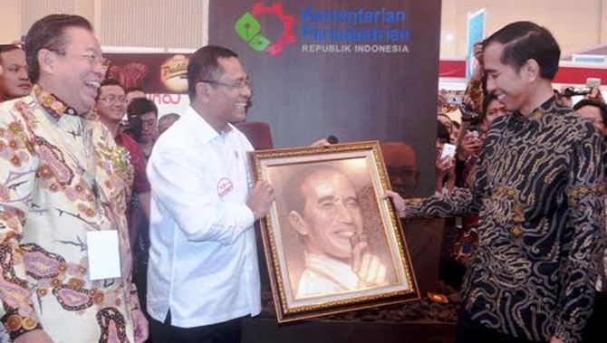 Menteri Perindustrian Saleh Husin menyerahkan lukisan yang terbuat dari cokelat kepada Presiden Joko Widodo disaksikan Managing Director Sinar Mas G. Sulistiyanto di Paviliun Kakao ketika meninjau Pameran "Dari Indonesia untuk Dunia" sebelum Peresmian Indonesia Convention Exhibition (ICE) di BSD City, Tangerang Selatan, Banten, 4 Agustus 2015.